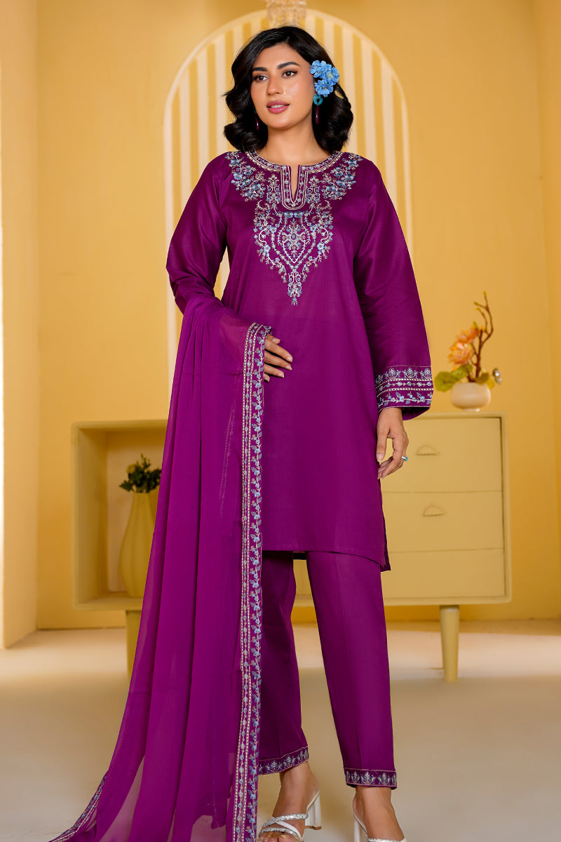 Woman wearing a purple embroidered outfit in a decorated room.