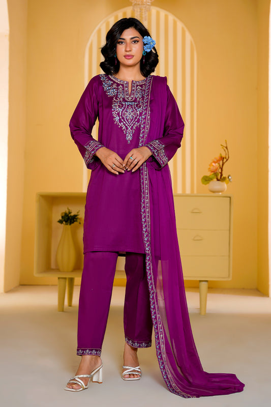 Woman wearing a purple embroidered outfit in a decorated room.