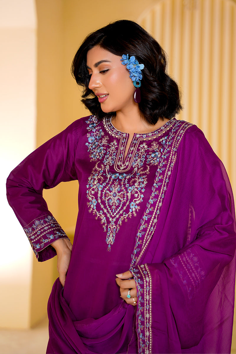 Woman wearing a purple embroidered traditional outfit with a blurred background