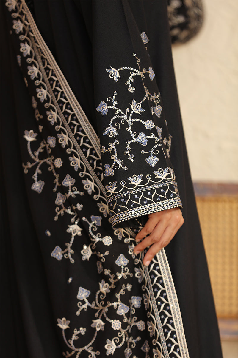 Black embroidered garment with intricate patterns on a neutral background