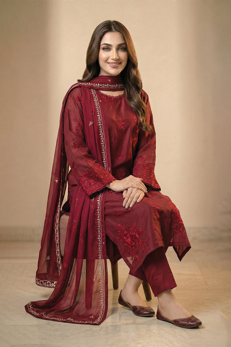 Woman wearing a red traditional outfit with intricate designs on a beige background