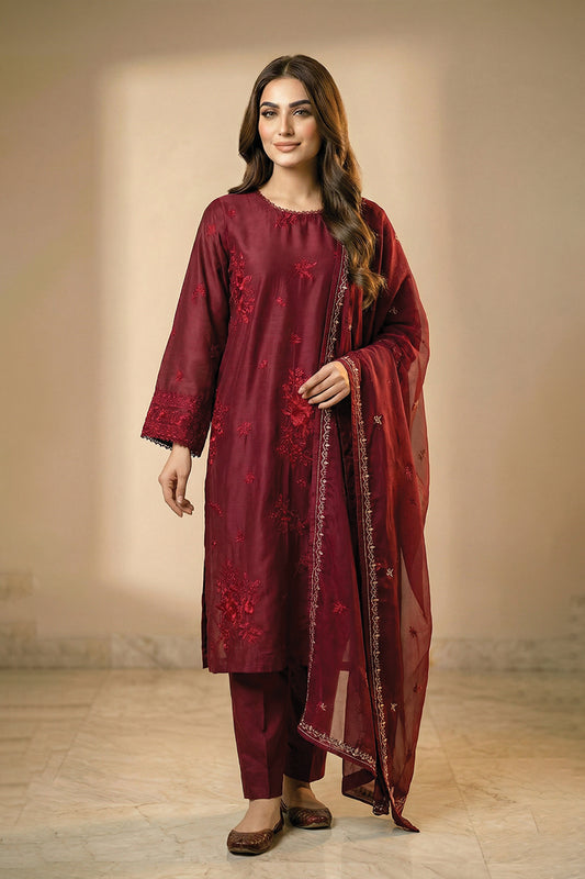 Woman wearing a maroon traditional outfit with a dupatta against a neutral background