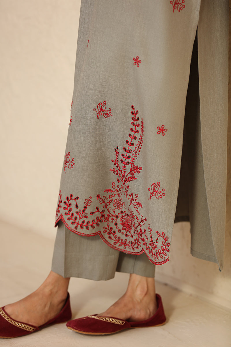 Gray outfit with red floral embroidery on a neutral background
