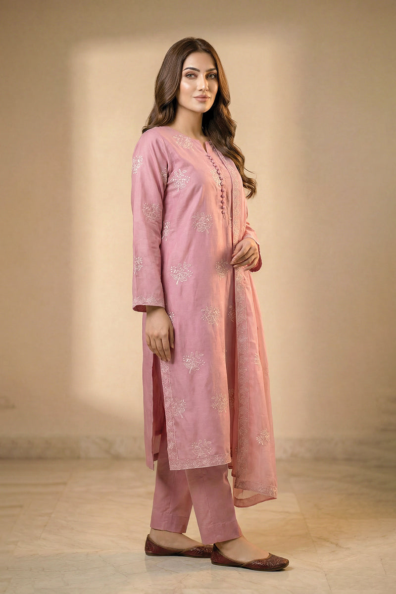 Woman wearing a pink traditional outfit with floral patterns on a neutral background