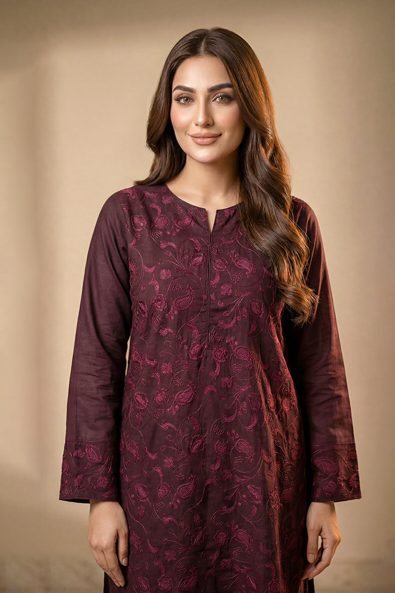 Woman wearing a purple kurta with floral pattern against a beige background