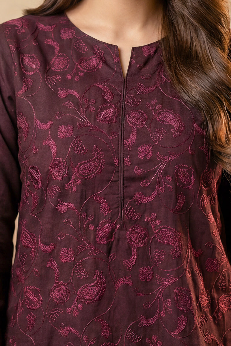 Close-up of a purple embroidered garment with intricate patterns.