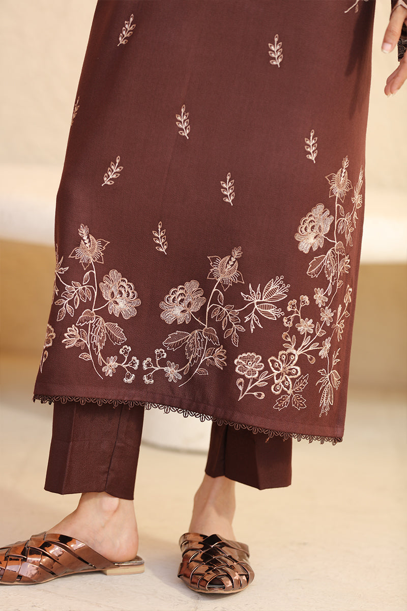 Brown embroidered fabric with floral patterns on a neutral background
