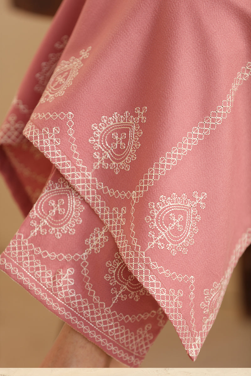 Pink fabric with white embroidery on a blurred background