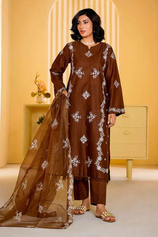 Woman wearing a brown embroidered outfit with a yellow background
