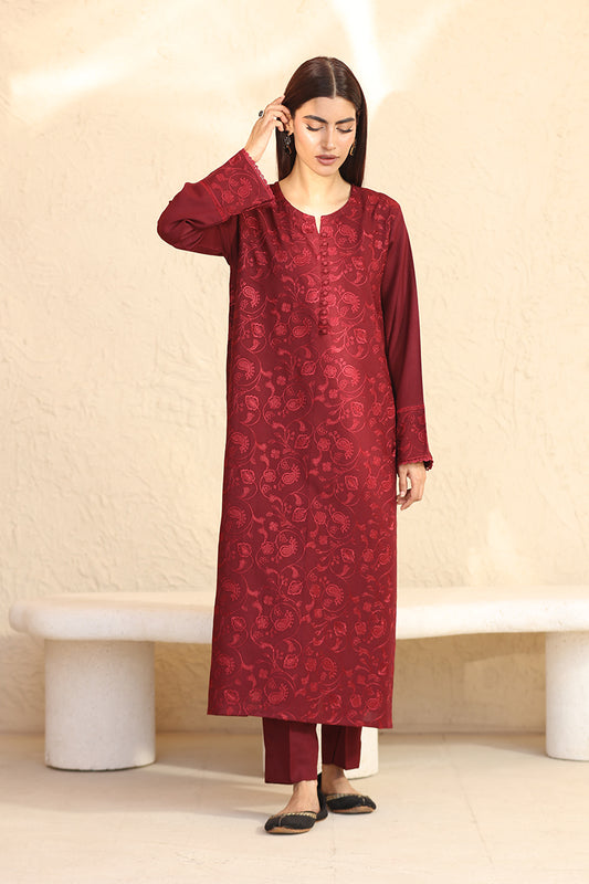 Woman wearing a red embroidered traditional outfit against a beige background
