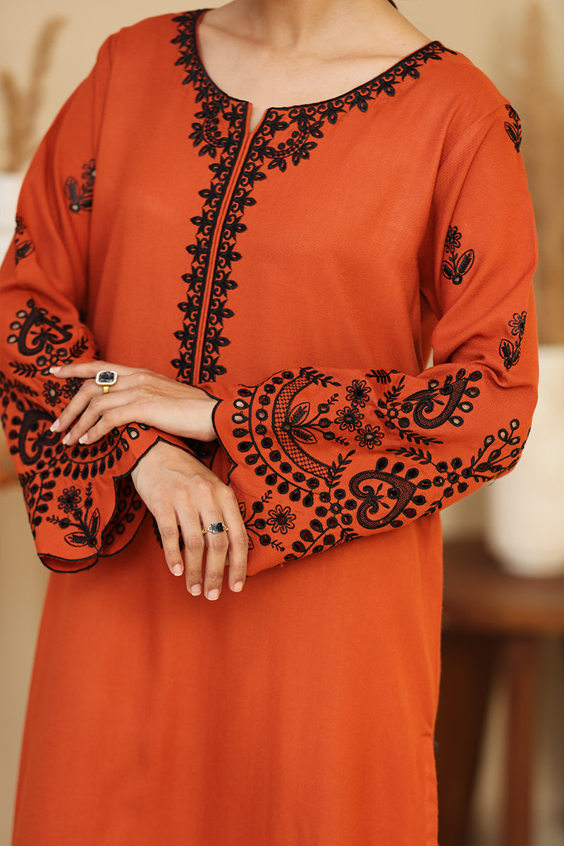 Orange kurta with black embroidery on a blurred background