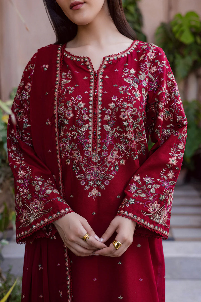 Woman wearing a red embroidered traditional outfit with a blurred background