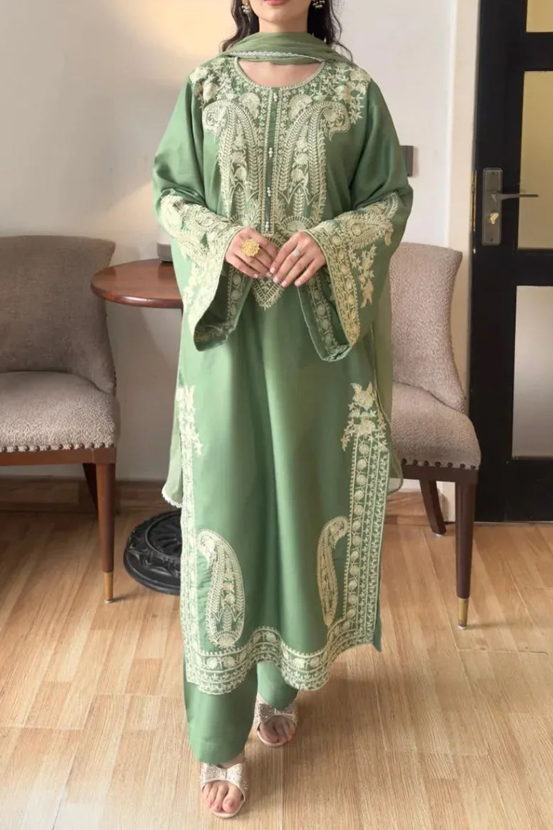 Woman wearing a green embroidered dress in an indoor setting