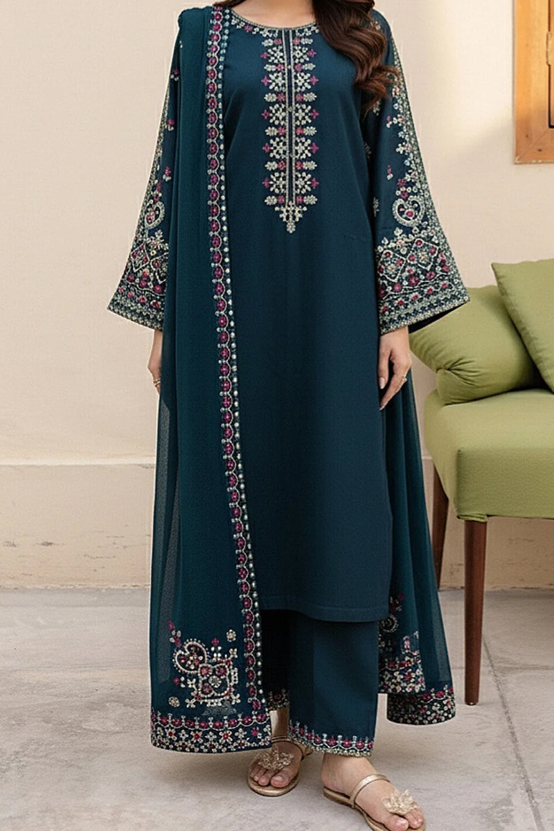 Woman wearing a teal embroidered outfit in a room with a green sofa.