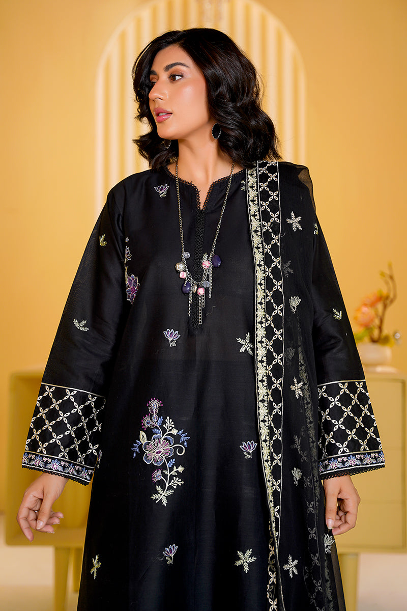 Woman wearing a black embroidered traditional outfit with a yellow background