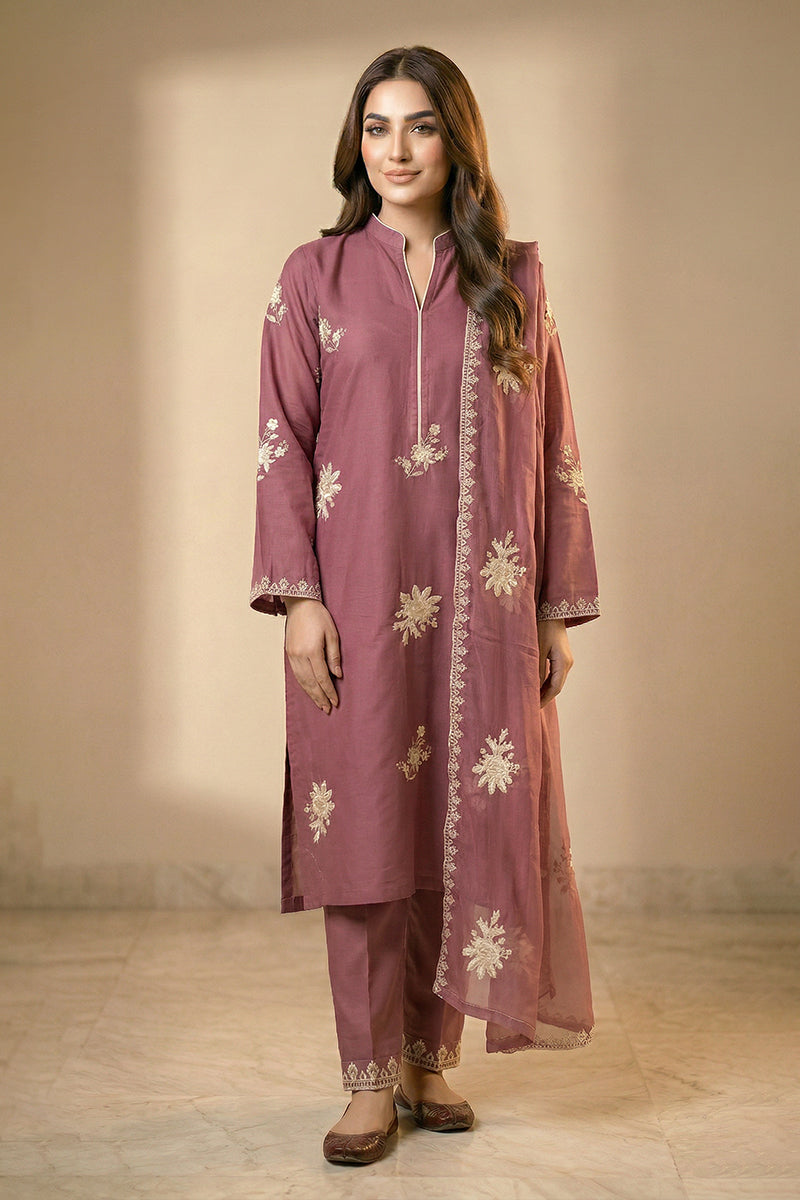 Woman wearing a mauve embroidered traditional outfit against a neutral background